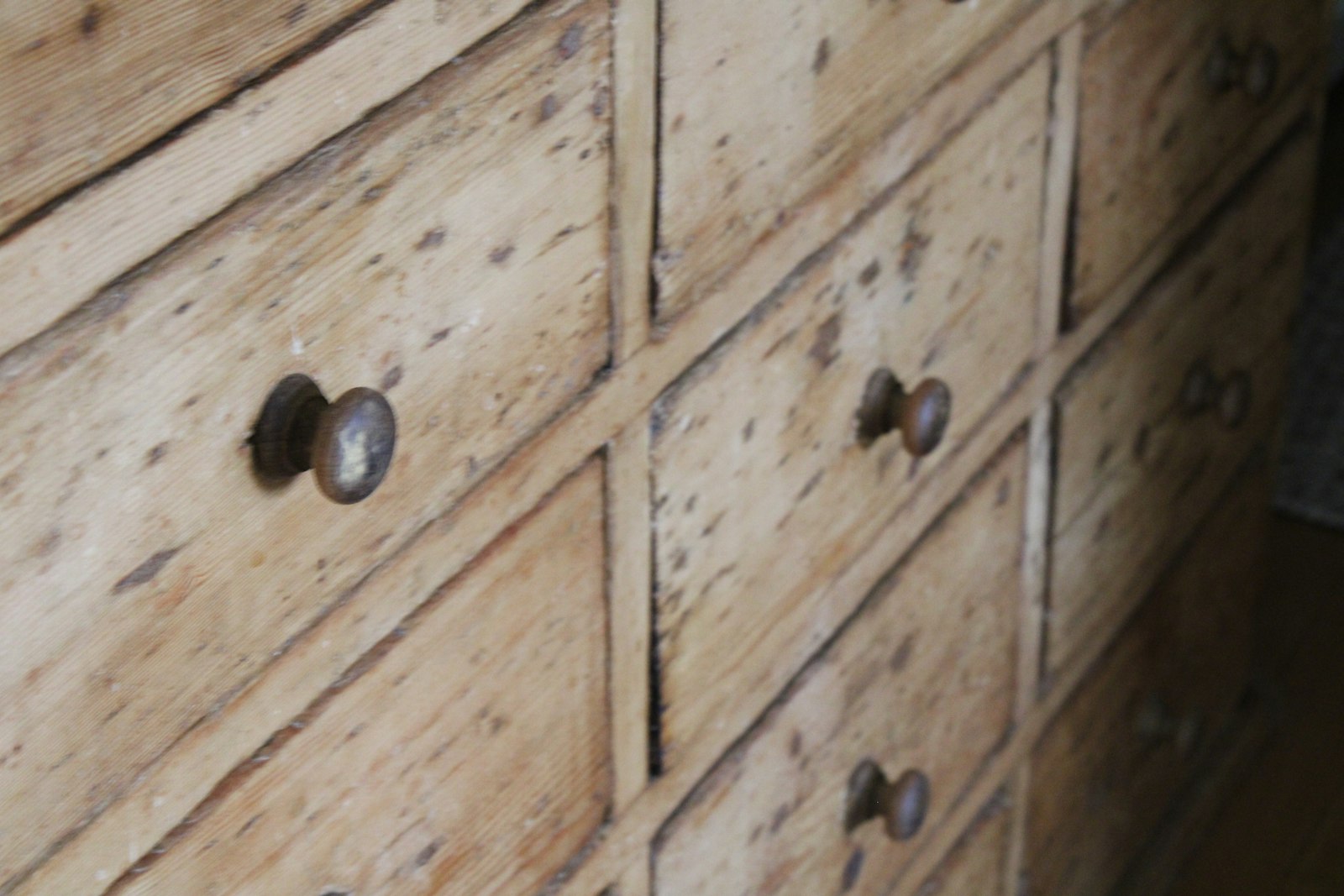 Close-up of wooden dresser drawers with dark round knobs