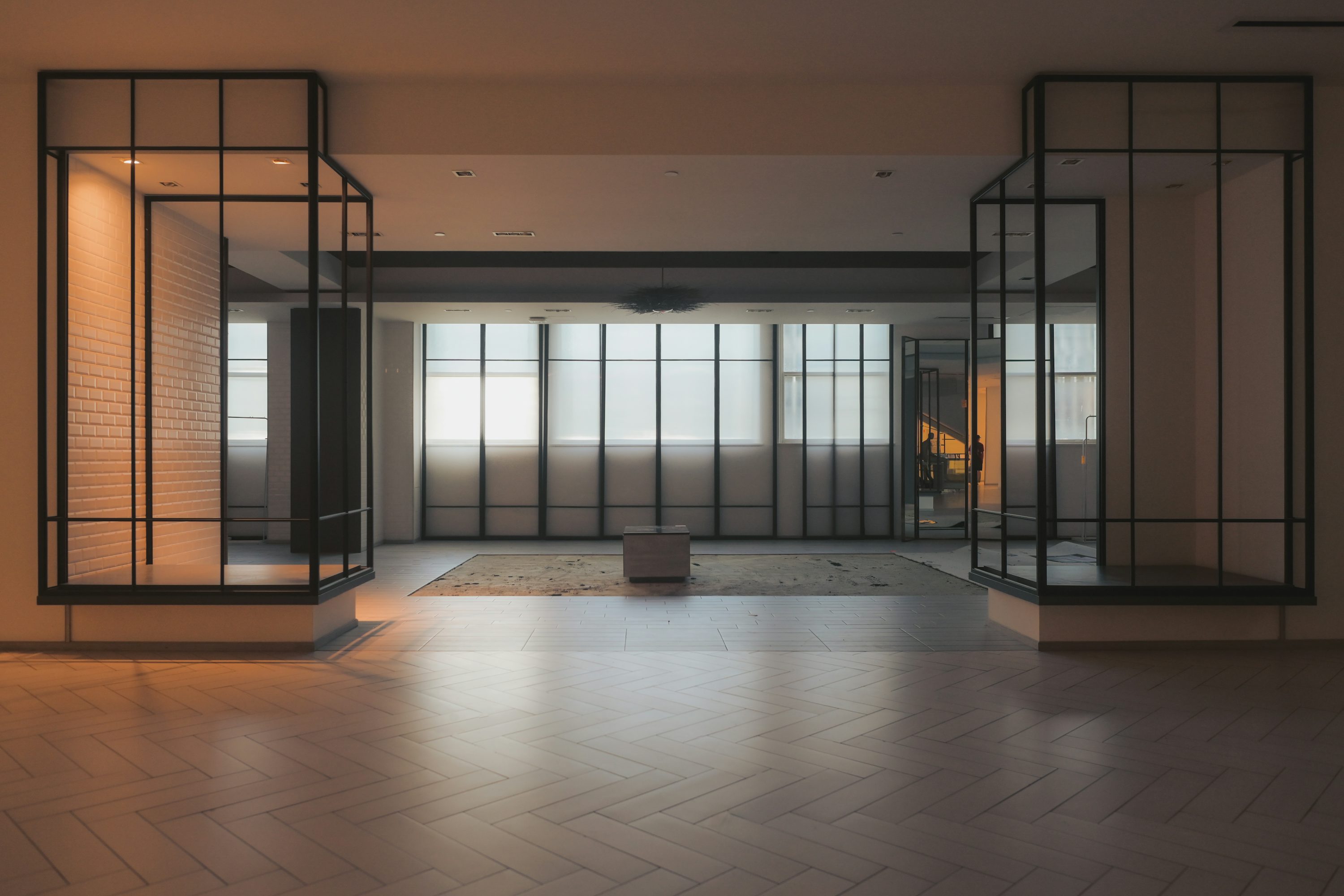 Warm light and black-framed partitions in an empty office interior