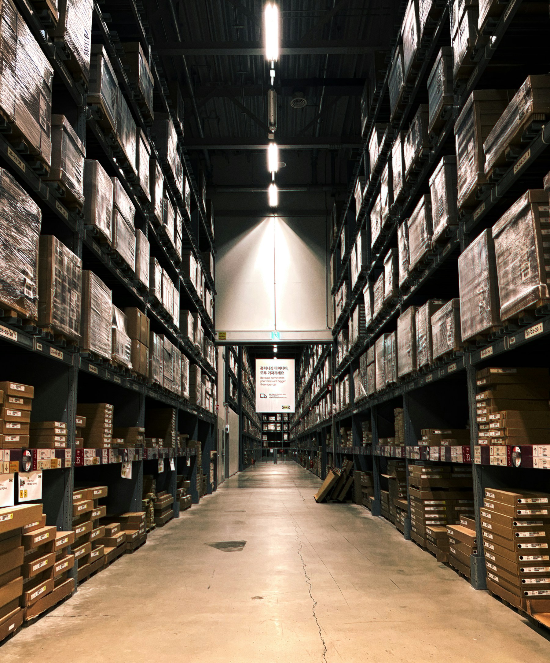 Warehouse aisle lined with stacked cartons and shelves