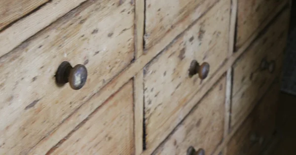 Close-up of wooden dresser drawers with dark round knobs