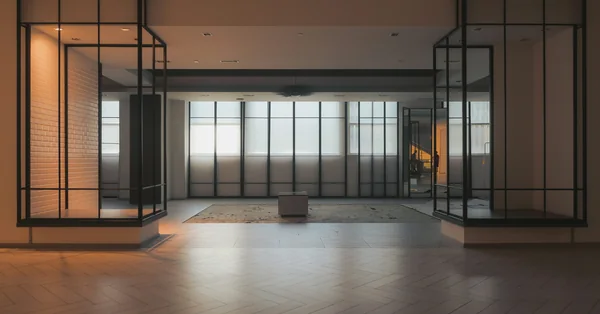 Warm light and black-framed partitions in an empty office interior