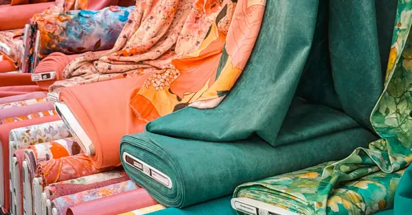 Teal and warm coral fabric rolls and draped textiles