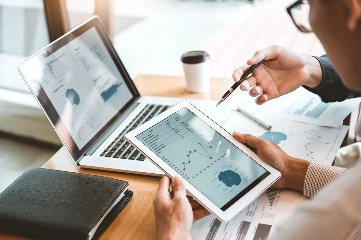 People reviewing charts on a laptop and tablet